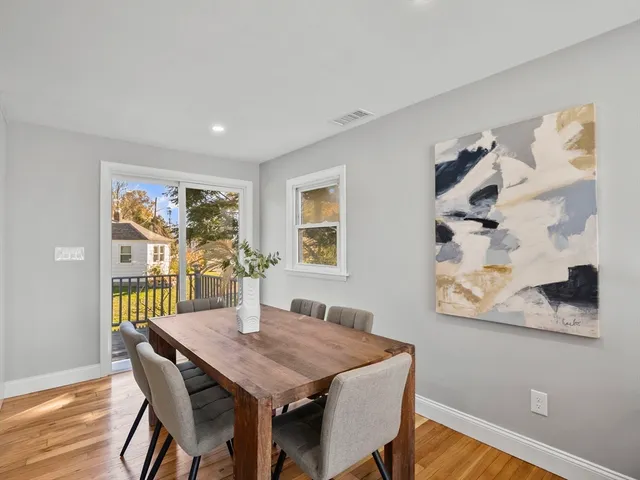 a view of a dining room with furniture a rug and wooden floor