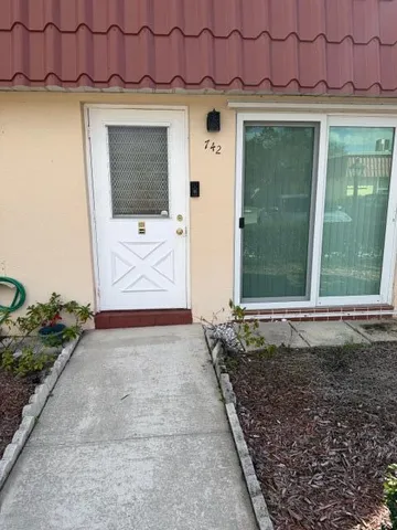 a front view of a house with a garden