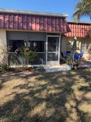 a view of a house with backyard porch and sitting area