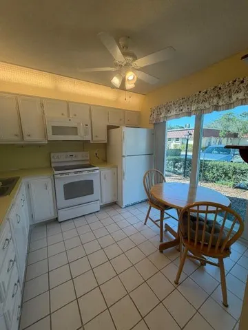 a kitchen with granite countertop a stove a sink and a microwave
