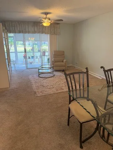 a furnished livingroom with windows and lounge chair
