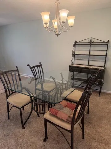 a living room with chairs and a chandelier