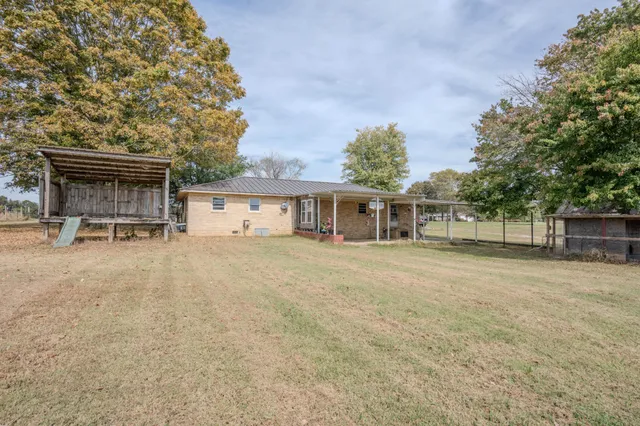 front view of a house with a yard and a large tree