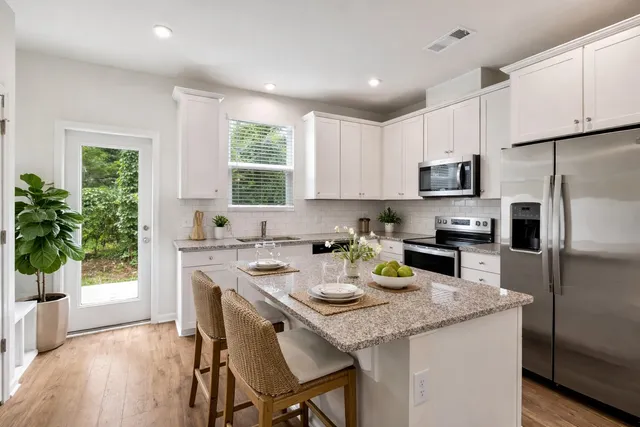 a kitchen with a sink a kitchen island and stainless steel appliances