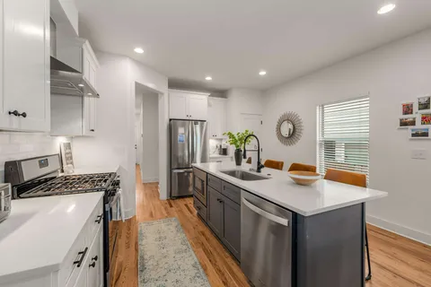 a kitchen with stainless steel appliances granite countertop a sink stove and refrigerator