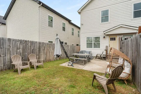 a view of a house with backyard and sitting area