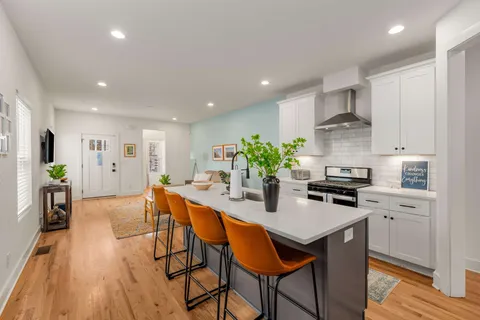 a kitchen with granite countertop white cabinets and stainless steel appliances