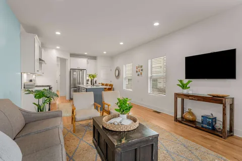 a living room with furniture a flat screen tv and a fireplace