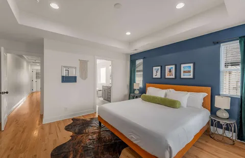 a bedroom with a bed and wooden floor