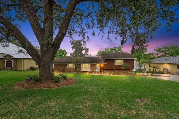 a front view of a house with a yard and trees