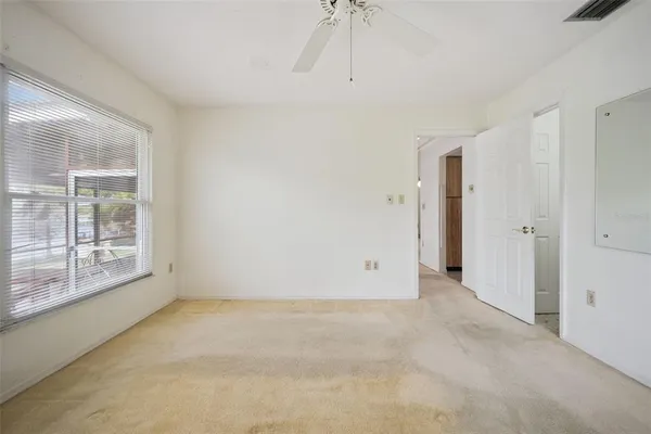 a view of an empty room with a window and wooden floor