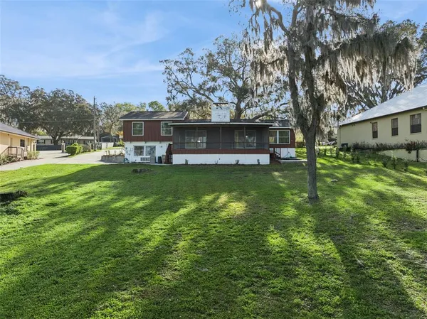 an aerial view of river residential houses with outdoor space and trees