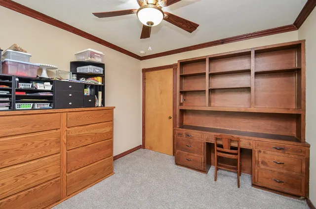 a view of an empty room with cabinet cabinet and a ceiling fan