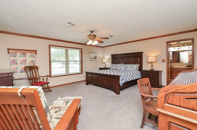 a bedroom with furniture a ceiling fan a fireplace and a window