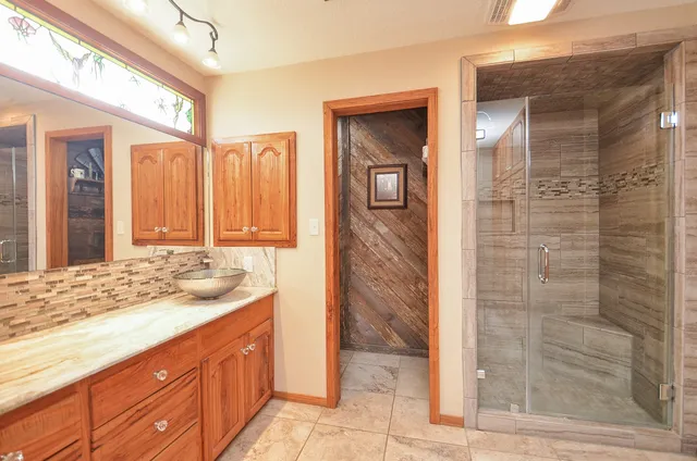 a bathroom with a granite countertop sink and a mirror