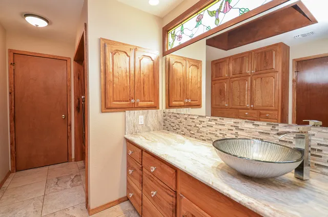 a view of a bathroom with a granite countertop sink and a bathtub