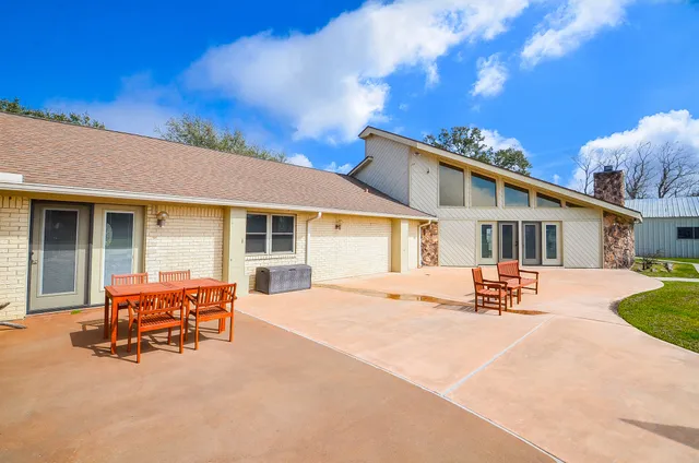 a patio with a table and chairs and a barbeque