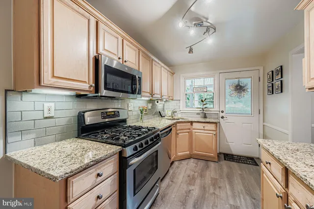 a kitchen with granite countertop a sink stove and cabinets