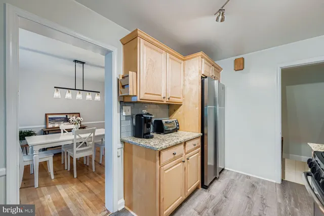 a kitchen with stainless steel appliances granite countertop a stove top oven a sink and a refrigerator