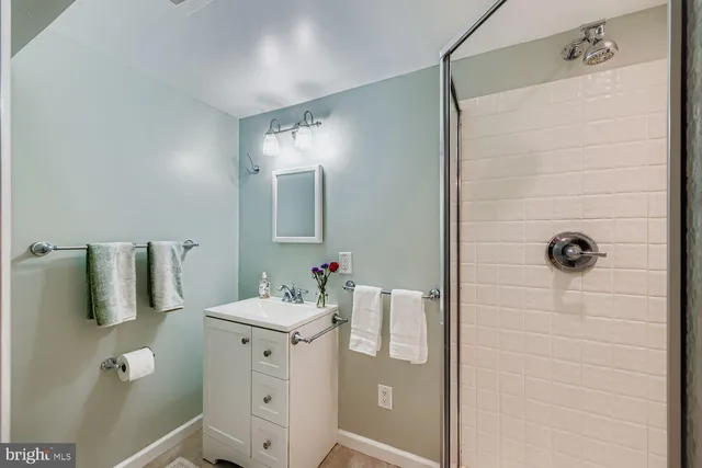 a bathroom with a sink vanity and shower