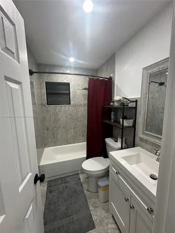a bathroom with a sink a toilet a mirror and shower