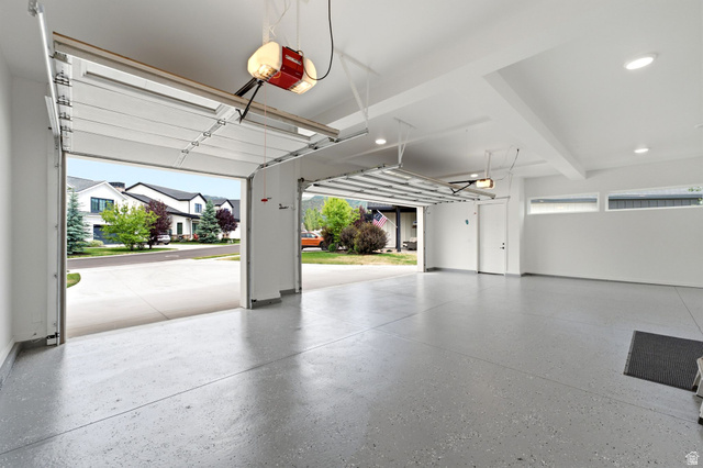 496 North Farmhouse Way, Unit 11 Midway, UT 84049 - Photo 45 of 50 Spacious two-car garage featuring a speckled epoxy floor, white walls, recessed lighting, and high ceilings