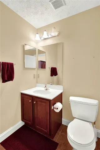 a bathroom with a toilet a sink and mirror