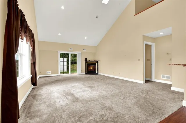 a view of an empty room with a window and fireplace