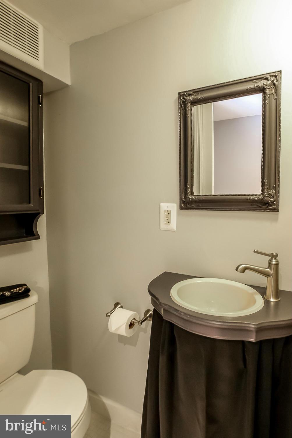 8329 Kavanagh Road Baltimore, MD 21222 - Photo 14 of 30 a bathroom with a toilet a sink and mirror