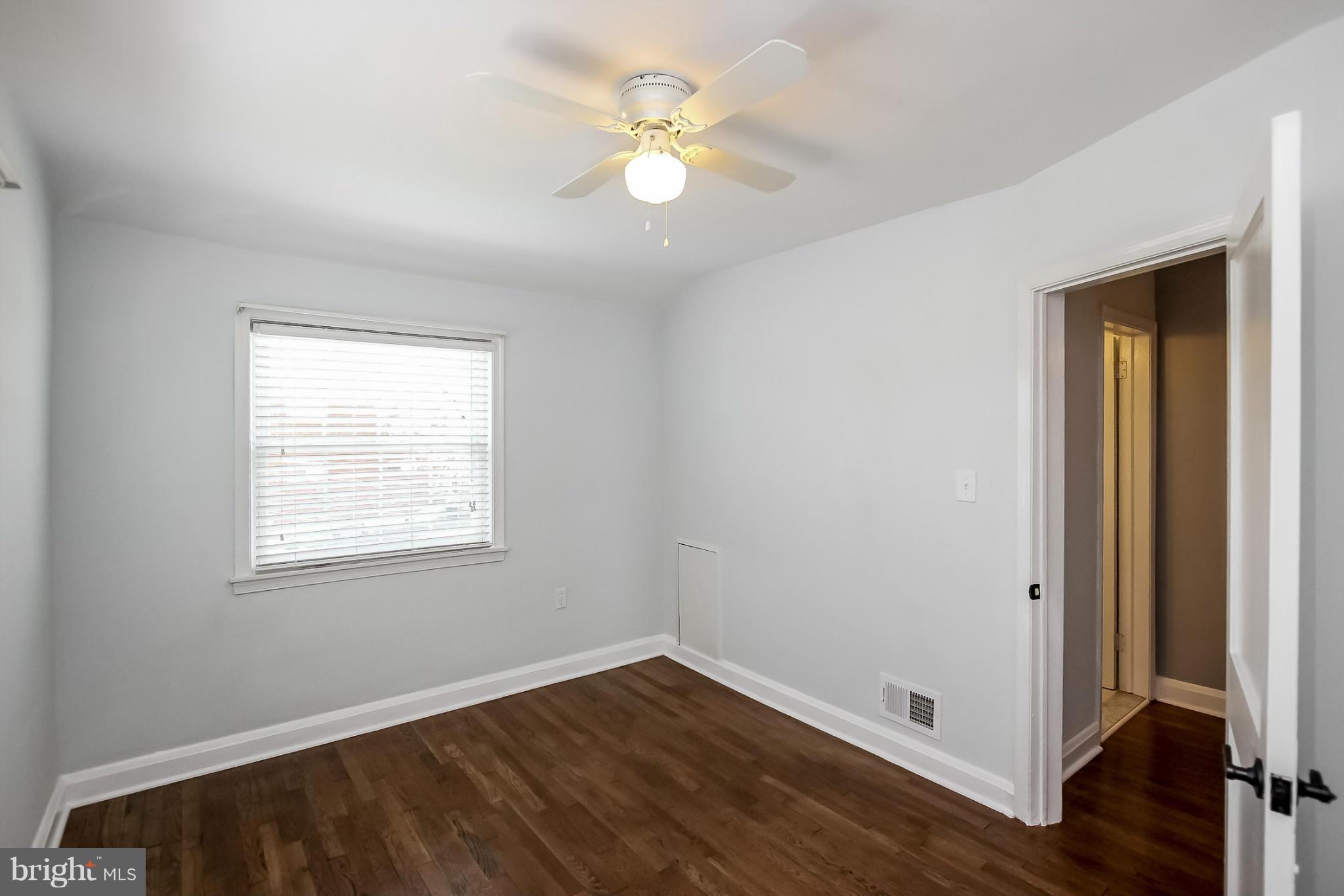8329 Kavanagh Road Baltimore, MD 21222 - Photo 21 of 30 wooden floor in an empty room with a window
