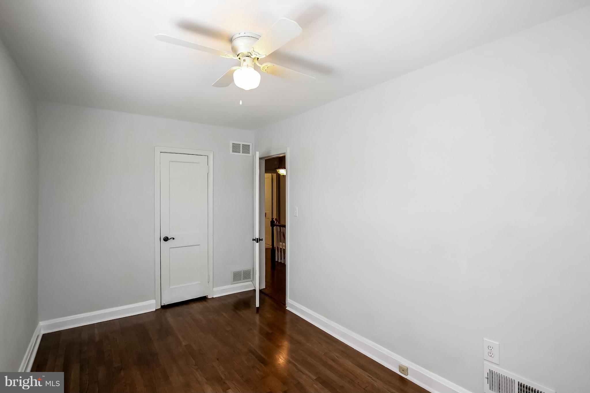 8329 Kavanagh Road Baltimore, MD 21222 - Photo 23 of 30 an empty room with wooden floor and fan