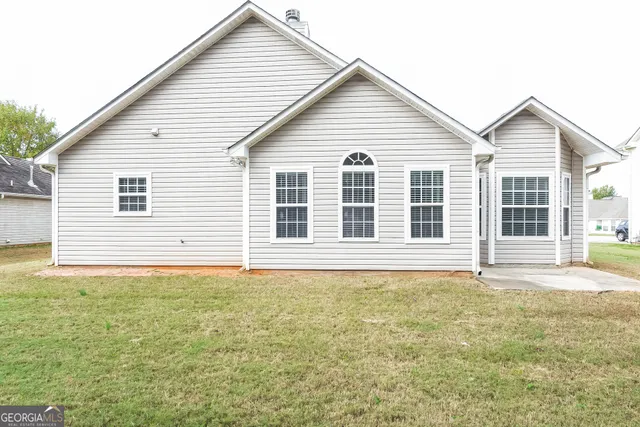 a view of a white house with a yard