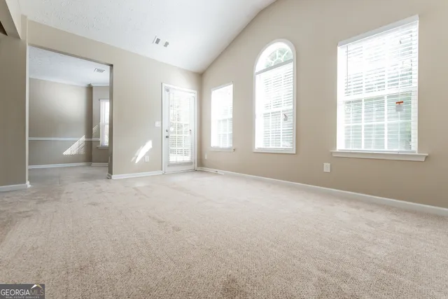 an empty room with windows and closet