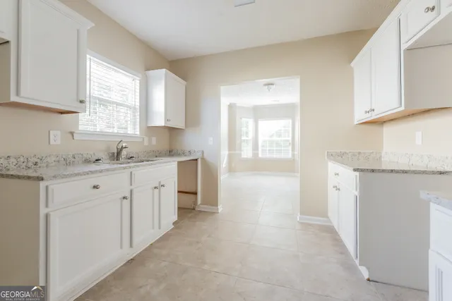a spacious bathroom with a granite countertop sink a mirror and a bathtub