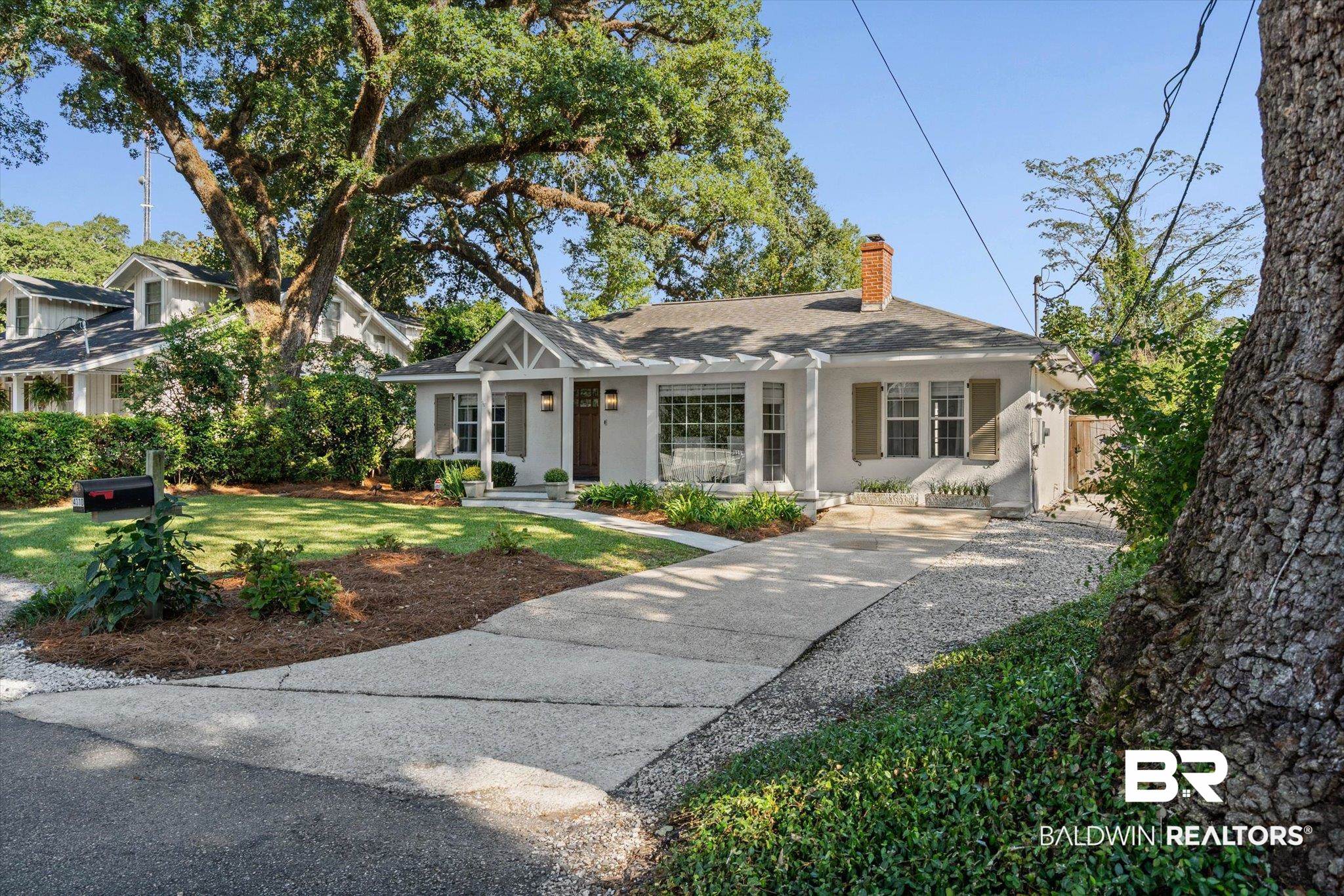 4310 The Cedars Avenue Mobile, AL 36608 - Photo 29 of 32 View of front of property featuring a chimney, a porch, stucco siding, and a front yard