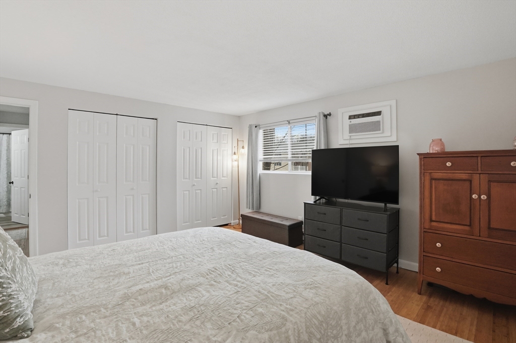 200 Manning Street, Unit 11C Hudson, MA 01749 - Photo 14 of 30 a bedroom with a bed and a flat screen tv in it
