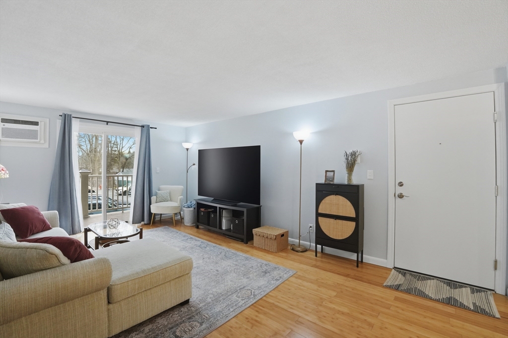 200 Manning Street, Unit 11C Hudson, MA 01749 - Photo 2 of 30 a living room with furniture a flat screen tv and a window