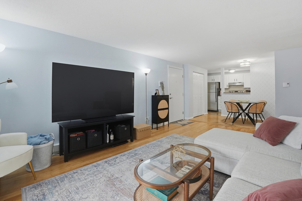 200 Manning Street, Unit 11C Hudson, MA 01749 - Photo 4 of 30 a living room with furniture and a flat screen tv
