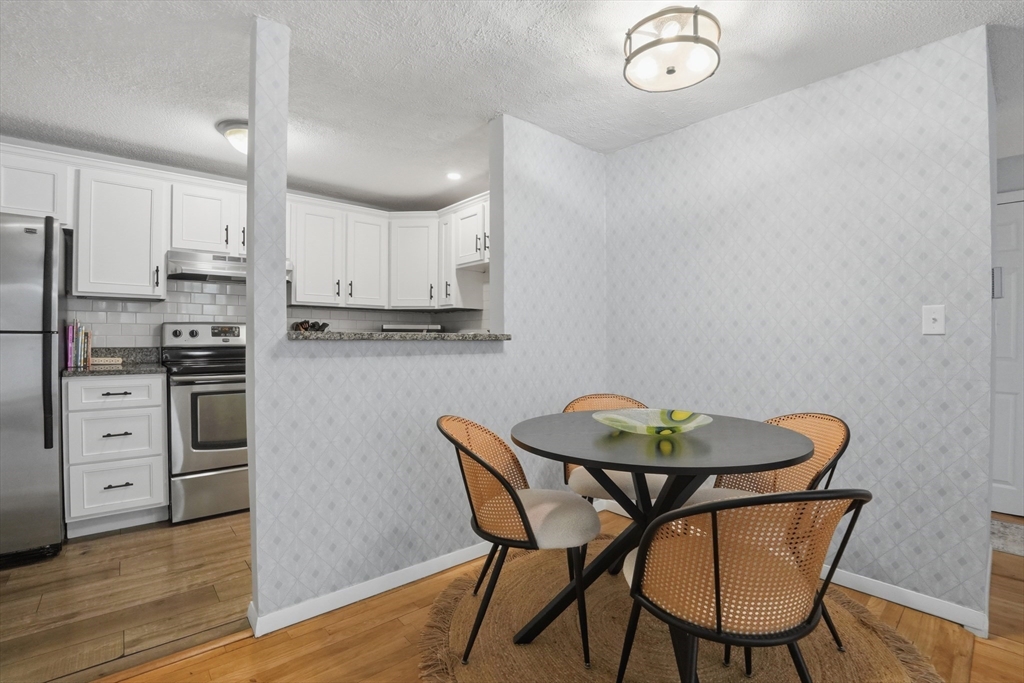 200 Manning Street, Unit 11C Hudson, MA 01749 - Photo 6 of 30 a view of a dining room with furniture and wooden floor
