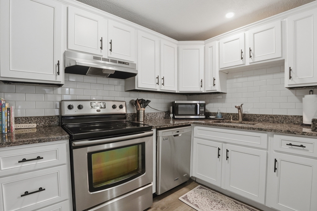 200 Manning Street, Unit 11C Hudson, MA 01749 - Photo 7 of 30 a kitchen with granite countertop white cabinets and appliances