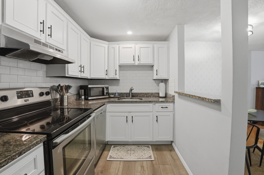 200 Manning Street, Unit 11C Hudson, MA 01749 - Photo 8 of 30 a kitchen with granite countertop a sink stainless steel appliances and cabinets