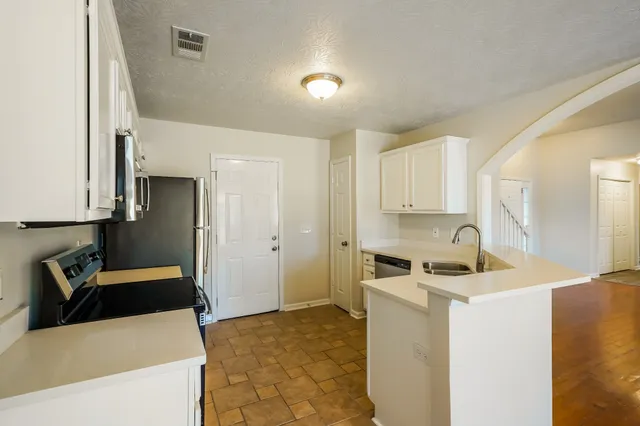 a kitchen that has a sink a stove and a refrigerator