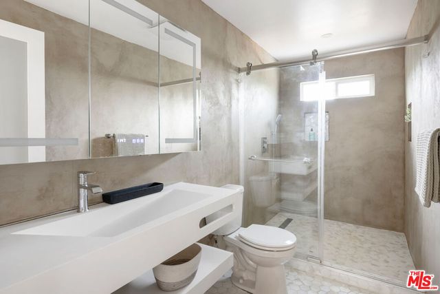 a bathroom with a sink toilet a mirror and shower