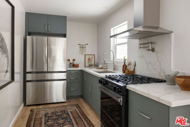 a kitchen with a stove a refrigerator and a stove top oven