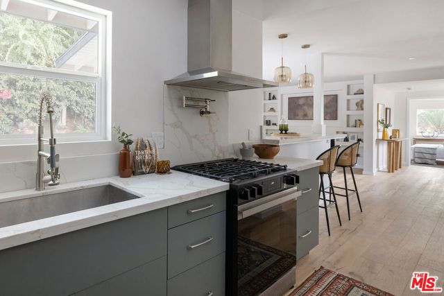 a kitchen with stainless steel appliances granite countertop a sink stove and cabinets