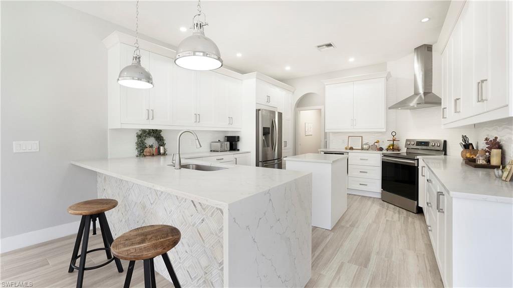 770 17th Street Southwest Naples, FL 34117 - Photo 17 of 47 a kitchen with white cabinets and stainless steel appliances