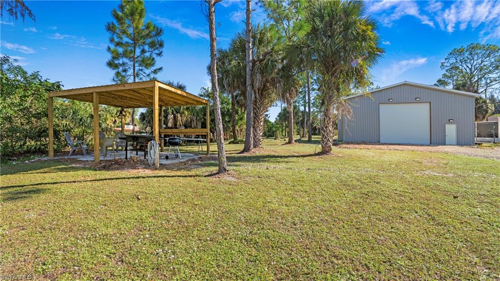 770 17th Street Southwest Naples, FL 34117 - Photo 34 of 47 a view of a swimming pool with a table and chairs under an umbrella