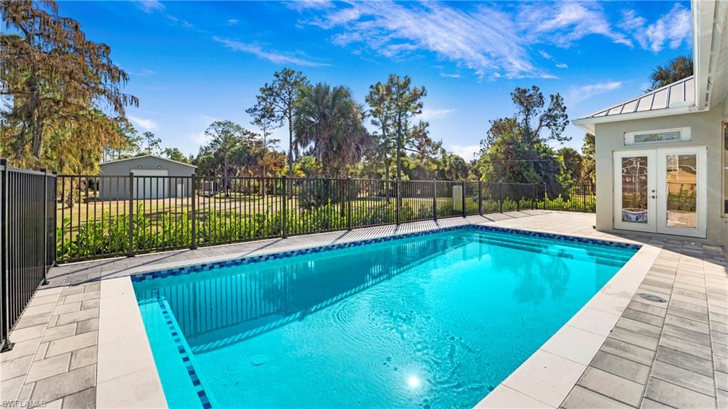770 17th Street Southwest Naples, FL 34117 - Photo 6 of 47 a view of swimming pool on a sunny day with lawn chairs