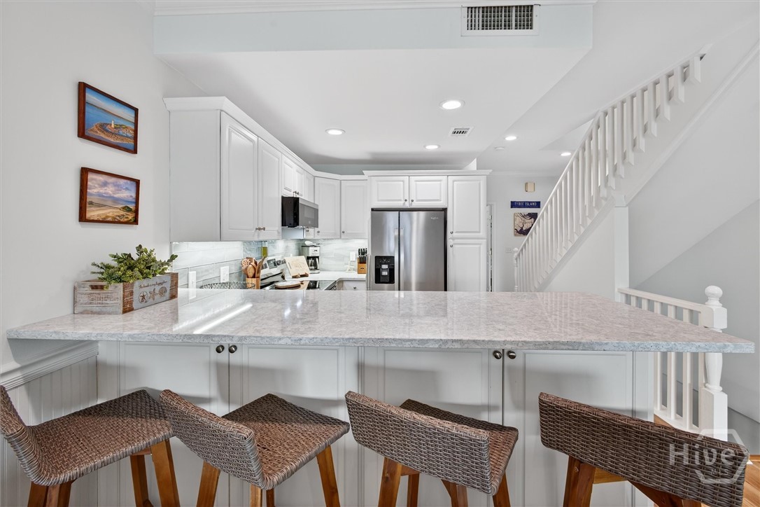 101 Butler Avenue, Unit G Tybee Island, GA 31328 - Photo 10 of 40 Gorgeous, well-equipped kitchen with quartz countertops, stainless steel appliances and tile backsplash.