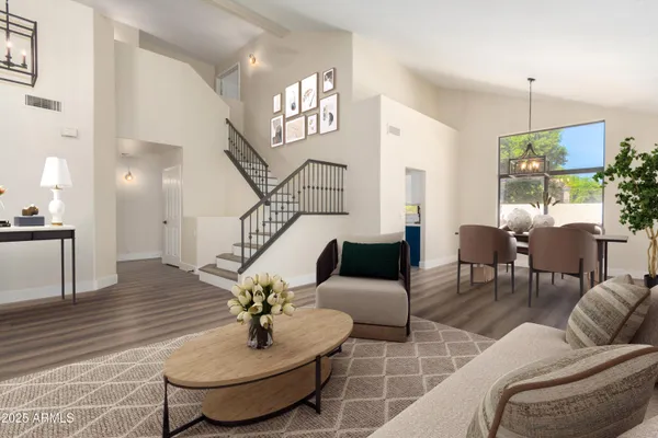 a living room with couches chairs and kitchen view with wooden floor